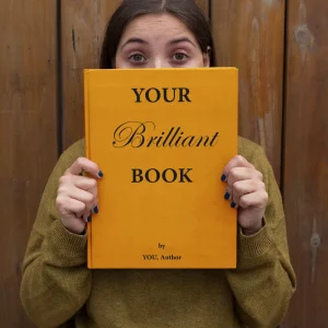 woman-holding-a-book-cover-mockup-with-her-eyes-wide-open